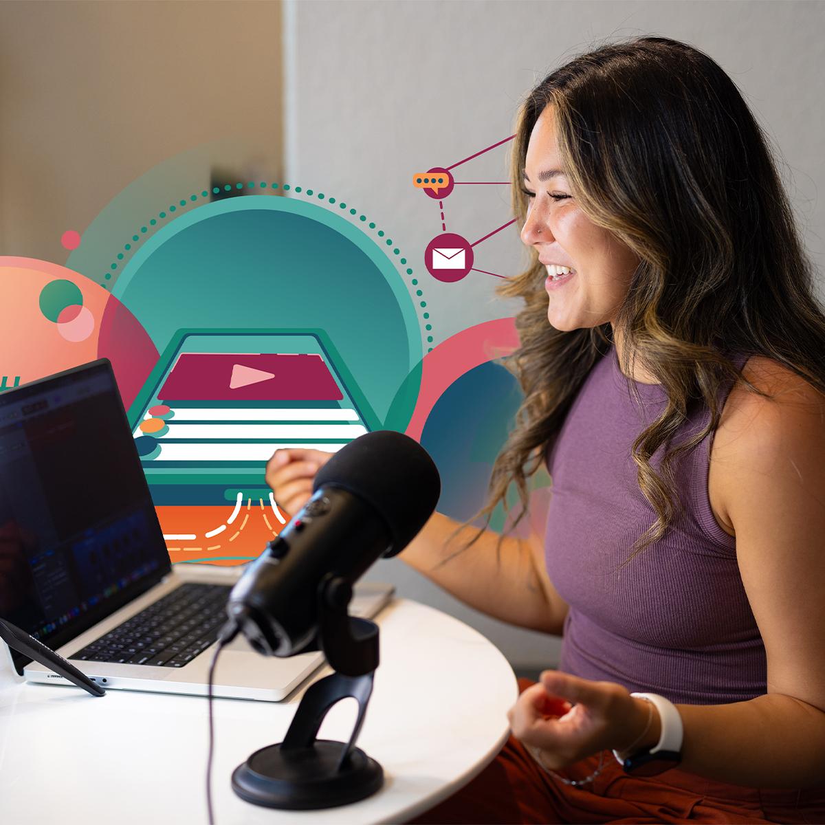 A person sits at a table, using a laptop and microphone to create content.